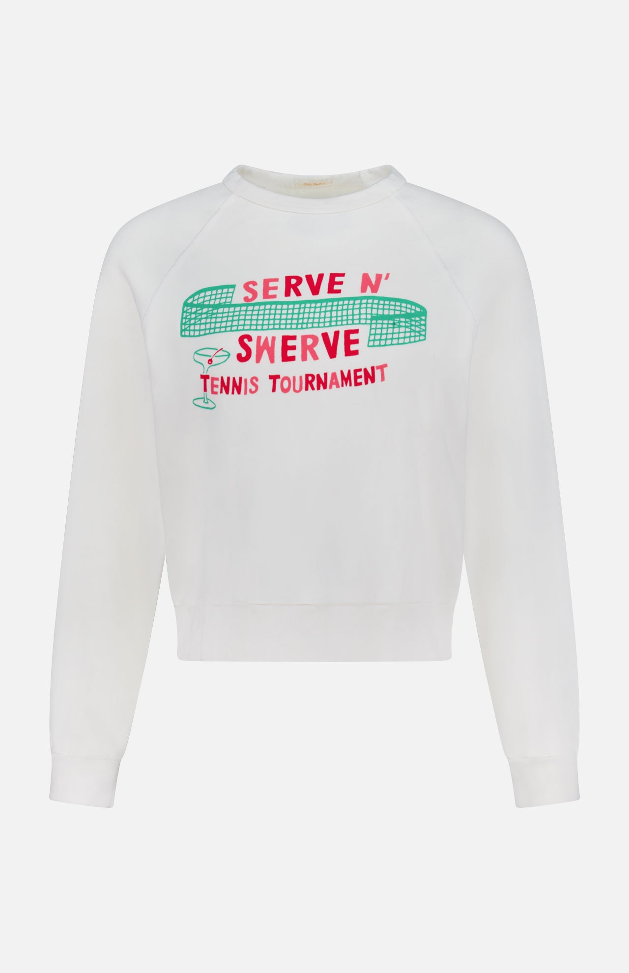The Itty Concert Tennis Sweater by MOTHER is a white 100% cotton cropped raglan sweatshirt with "SERVE N SWERVE TENNIS TOURNAMENT" in red and green, plus bold net, ball, and racket graphics above the text.