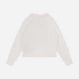 The Itty Concert Tennis Sweater by MOTHER is shown laid flat on a white background, featuring a plain, long-sleeved design in light beige 100% cotton with a back view and no visible logos or designs.