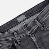 Close-up of the waistband and front pockets of The Jinx Sneak Jeans in Cliffhanger by MOTHER, featuring a metal button, belt loops, and a branded label. Crafted from stretch denim in a flattering bootcut silhouette, shown on a white background.