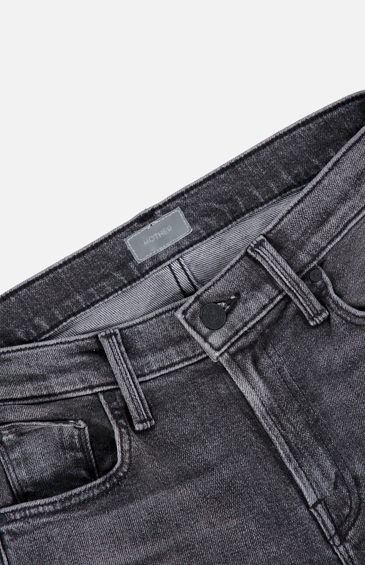 Close-up of the waistband and front pockets of The Jinx Sneak Jeans in Cliffhanger by MOTHER, featuring a metal button, belt loops, and a branded label. Crafted from stretch denim in a flattering bootcut silhouette, shown on a white background.