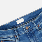 A close-up of the waistband and upper portion of MOTHER’s The Kick It Straight Leg Jean in Bitchin', a high-rise, mid-blue style, highlights the button, belt loops, front pockets, and a blank white label inside.