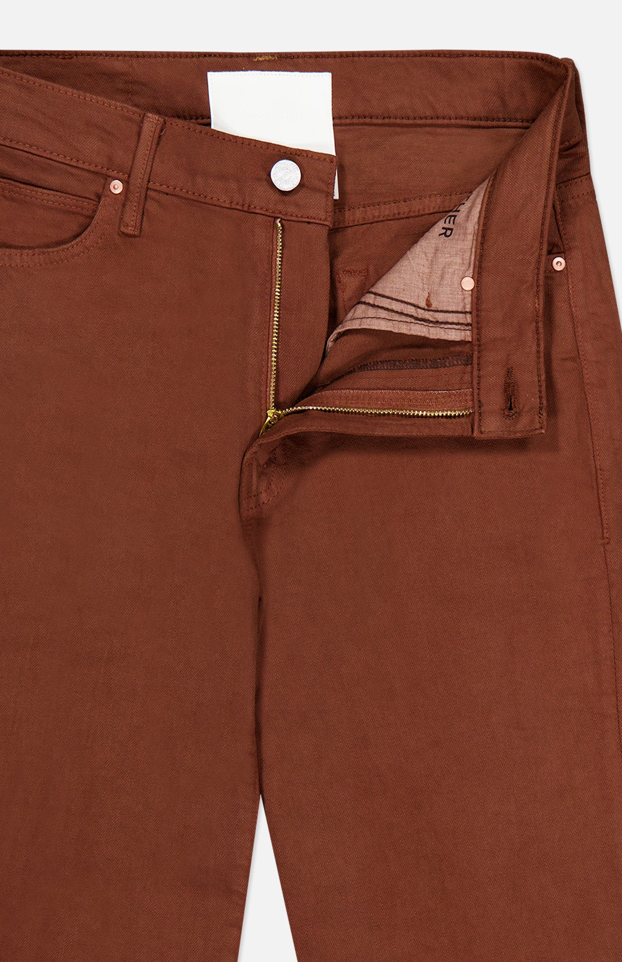 A close-up of The Kick It Pant in Bison by MOTHER showcases the high-rise silhouette, with a visible zipper and button fly partially unzipped to reveal pocket lining and waistband details. The straight-leg cut is subtly highlighted, emphasizing the pant’s classic style elements.