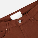 Close-up of the waistband and front button of The Kick It Pant in Bison by MOTHER, featuring belt loops, a straight-leg fit, front pockets, and a white label inside the waistband.