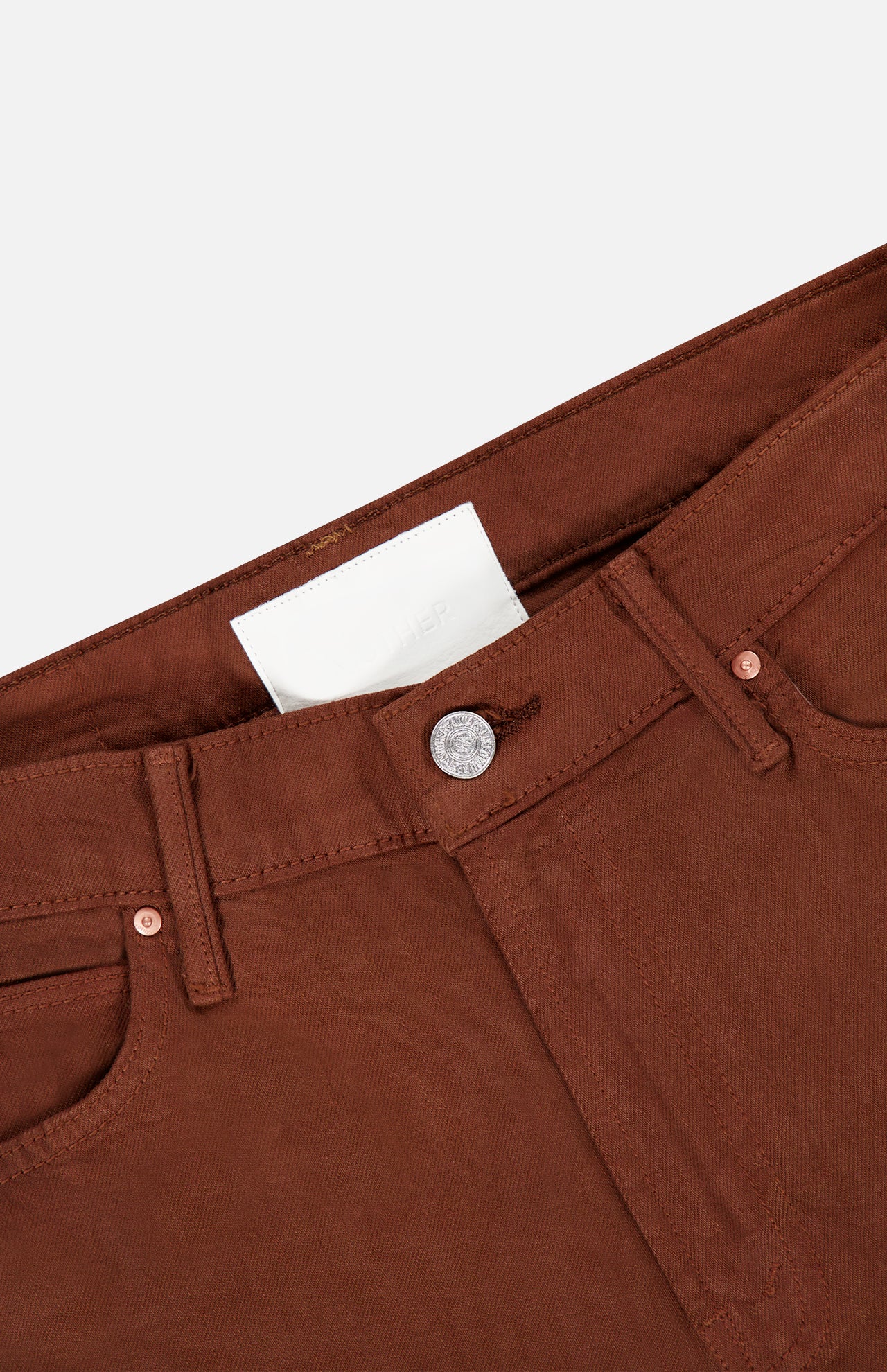 Close-up of the waistband and front button of The Kick It Pant in Bison by MOTHER, featuring belt loops, a straight-leg fit, front pockets, and a white label inside the waistband.