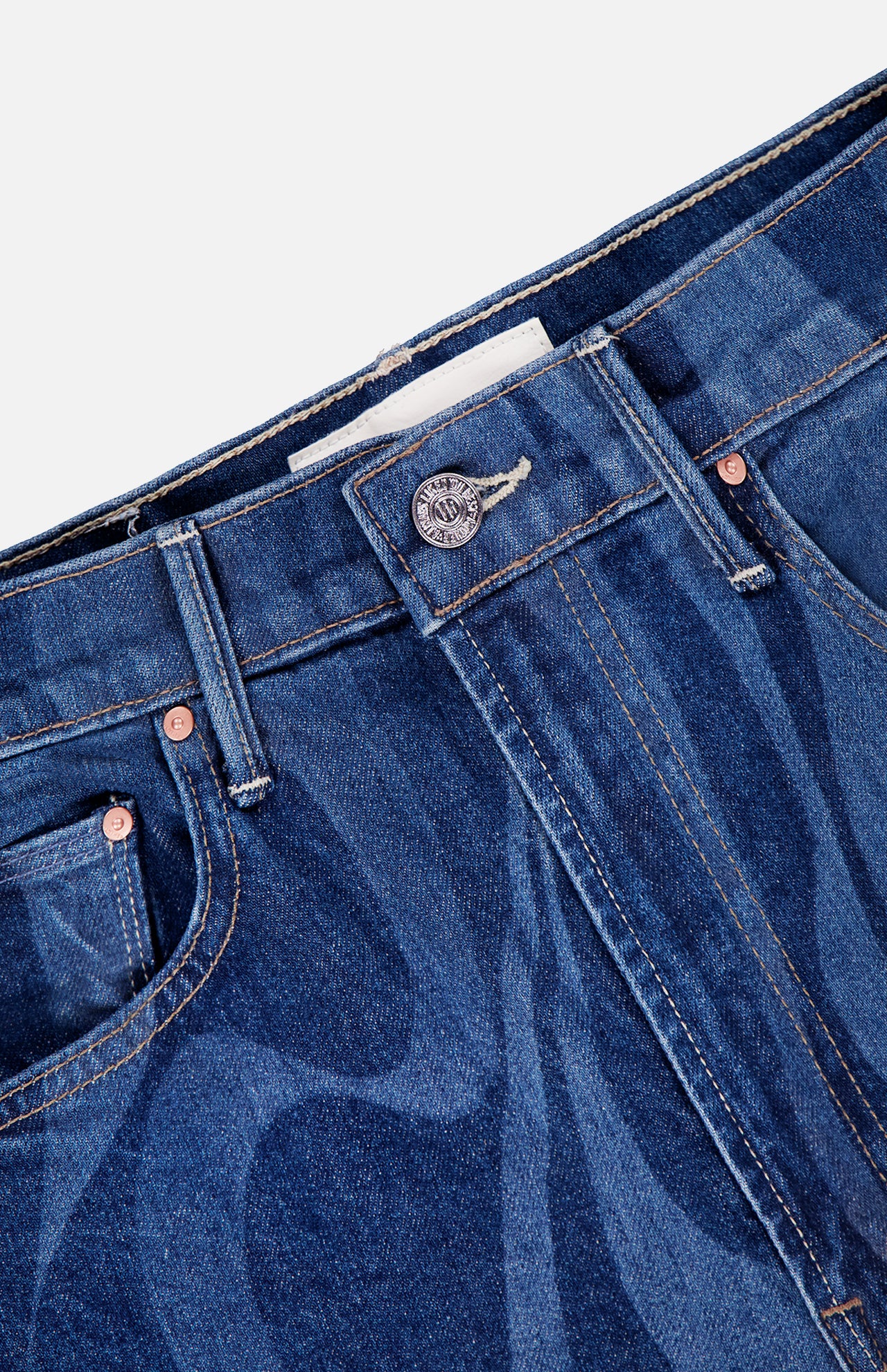 Close-up of the waistband and top front section of The Lasso Sneak Abstract Print Jean by MOTHER, featuring a blue high rise wide leg design with swirling abstract stripes, visible button, belt loops, pocket rivets, and part of a white inner label.