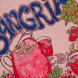 The Lil Goodie Ringer Sangria T-shirt by MOTHER features a bold fruity sangria graphic with oranges, grapes, strawberries, and cherries on pink recycled cotton-blend, plus SANGRIA in large blue letters above.