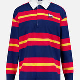 The Long Sleeve Huddle Shirt by MOTHER features bold navy, red, and yellow stripes, a classic white collar, and an embroidered white dog with a black patch. Made from recycled cotton for comfort and sustainability.