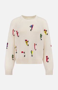The Raglan Pullover Sweater by MOTHER is a cream-colored 100% cotton sweater with colorful abstract embroidered figures in various poses across the front, sleeves, and body.