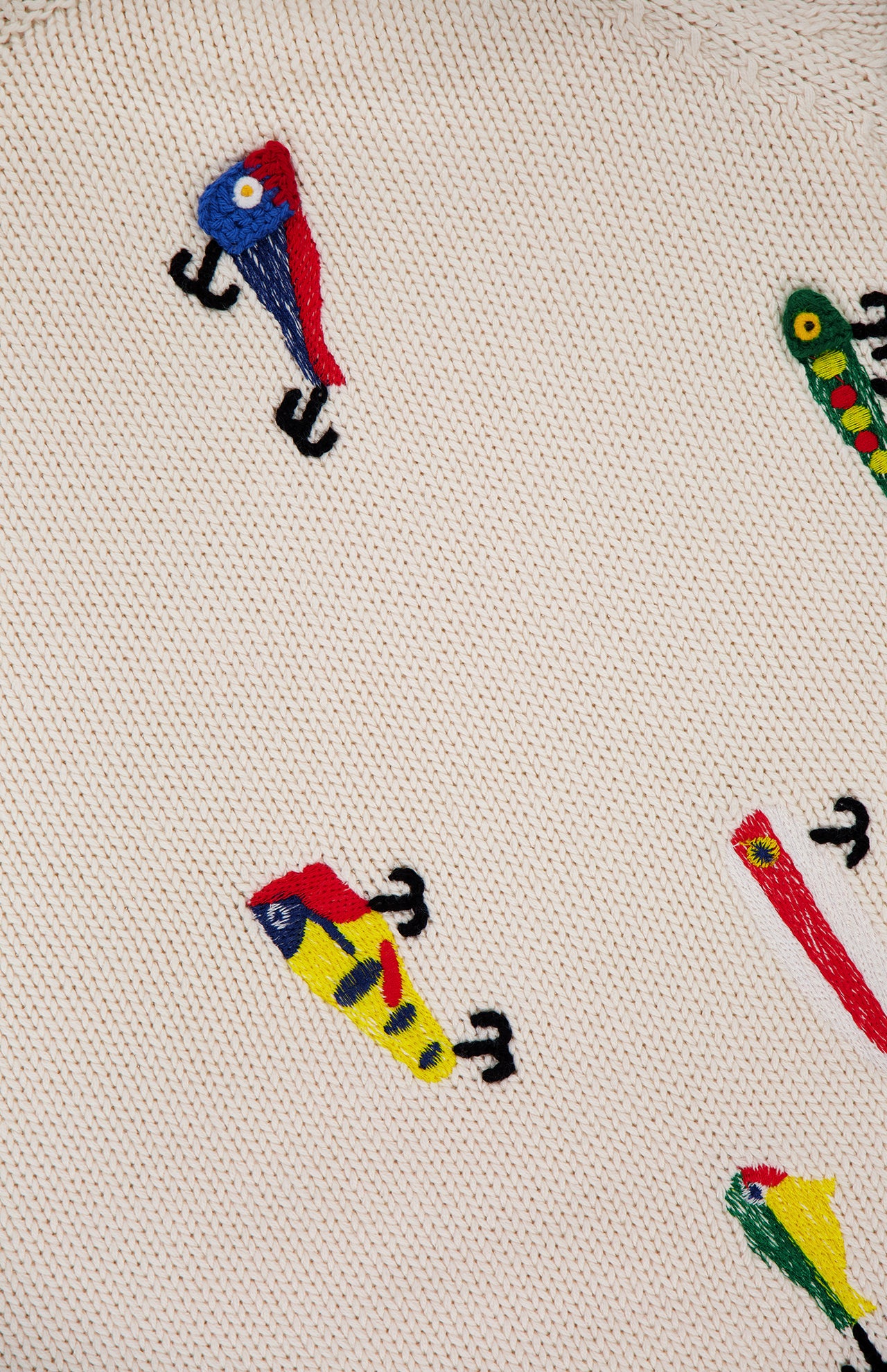 The Raglan Pullover Sweater by MOTHER is a beige 100% cotton top, playfully decorated with embroidered, colorful birds and caterpillars in bright blues, yellows, reds, and greens.