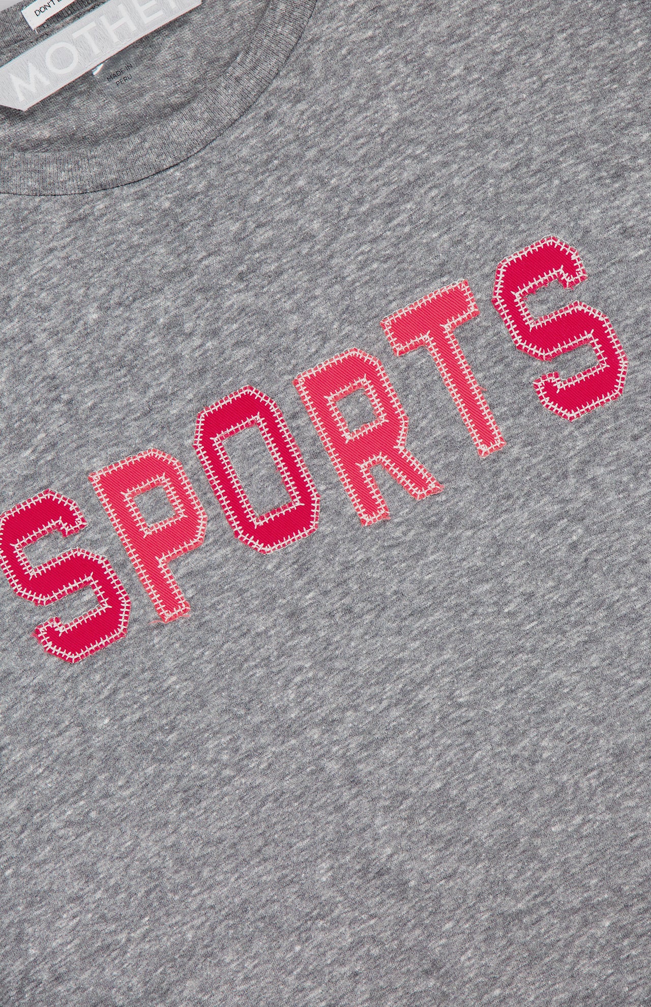 A close-up of The Rowdy Sports T-Shirt by MOTHER, featuring a grey crew neck design in heathered cotton-blend fabric.
