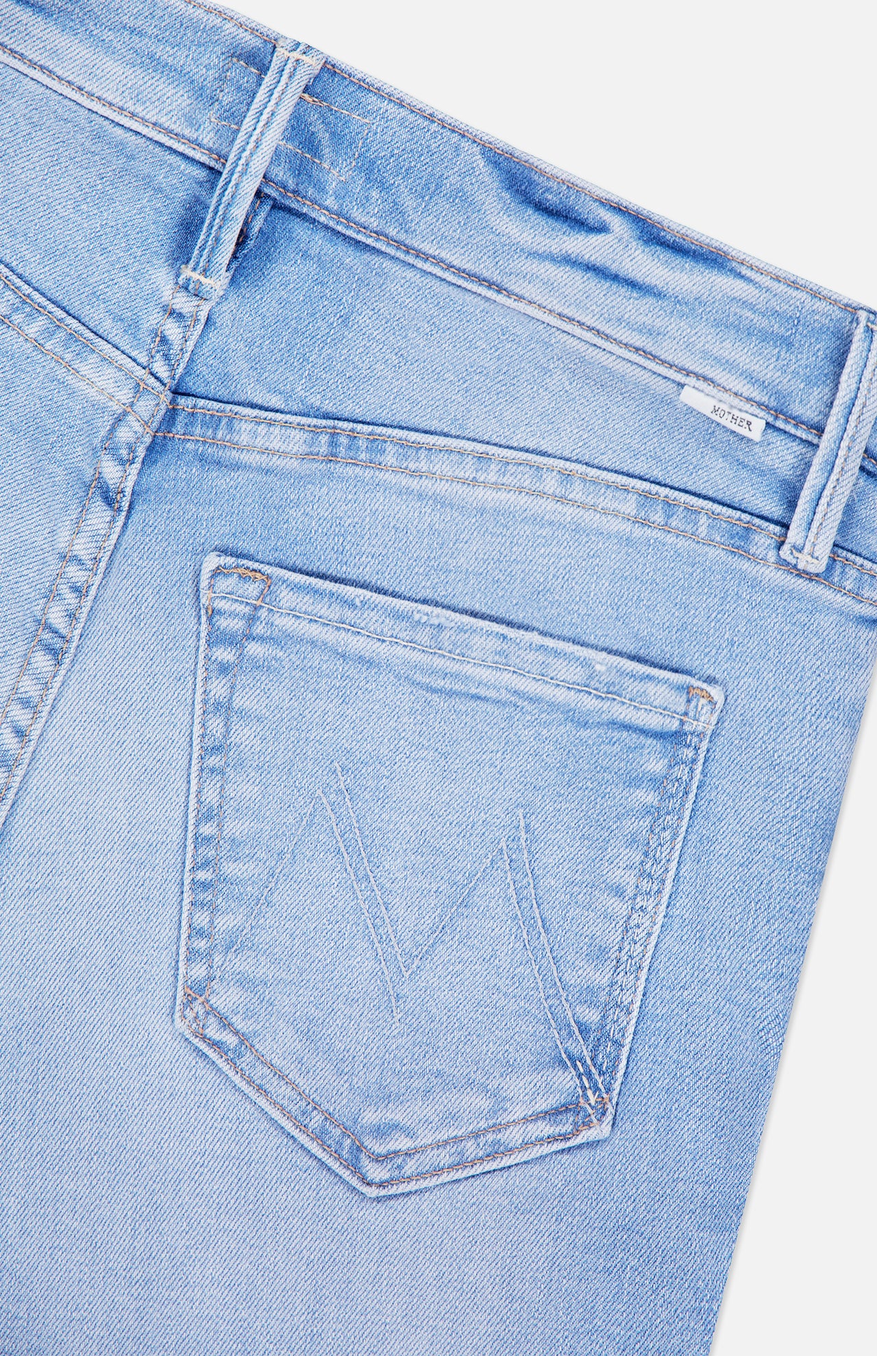 Close-up of The Runaway Skinny Jean in Derby Doll by MOTHER, showcasing the back pocket with stitched V-shaped detailing. The visible waistband and belt loops highlight these stylish mid rise jeans.
