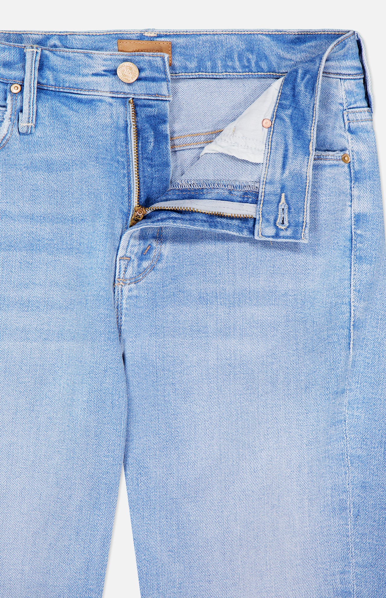 The Runaway Skinny Jean in Derby Doll by MOTHER features a light blue wash with the waistband and zipper partly open, revealing the white inner lining and contrast stitching. These mid-rise jeans include front pockets accented with copper rivets and a small coin pocket on the right.