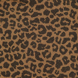 Close-up of brown cotton linen blend fabric with a black cheetah print pattern from The Short Sleeve Boxy Ringer T-shirt by MOTHER, showing part of a round neckline and a clothing label at the top edge.