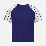 The Concert Race T-shirt by MOTHER is a 100% cotton raglan tee featuring a solid navy blue back and white sleeves with navy blue stars, inspired by classic Americana style. Shown against a plain white background.