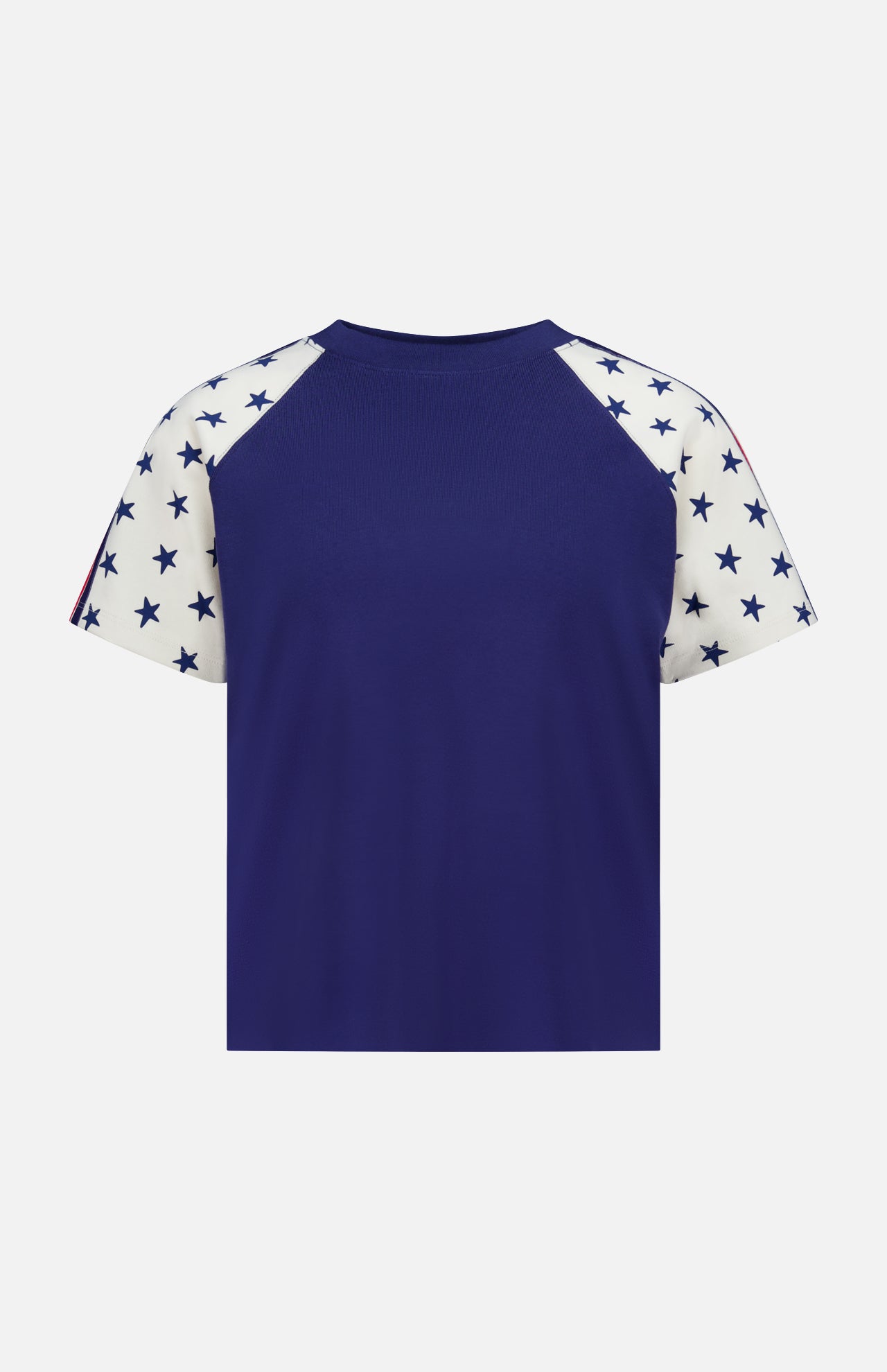 The Concert Race T-shirt by MOTHER is a 100% cotton raglan tee featuring a solid navy blue back and white sleeves with navy blue stars, inspired by classic Americana style. Shown against a plain white background.