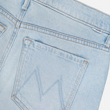 Close-up of the back pocket of MOTHER’s The Vagabond Mini Fray Skirt, a light blue denim style with a stitched M on the pocket, visible waistband and belt loop, plus a subtle frayed hem.