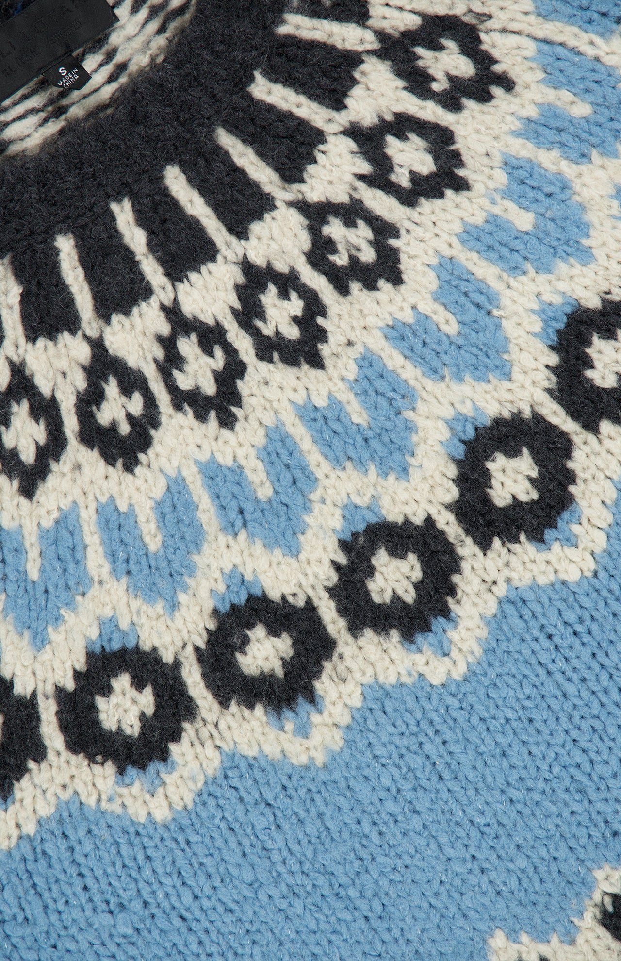 Close-up of the Nili Lotan Isaline Fair Isle sweater featuring a black, light blue, and cream pattern.