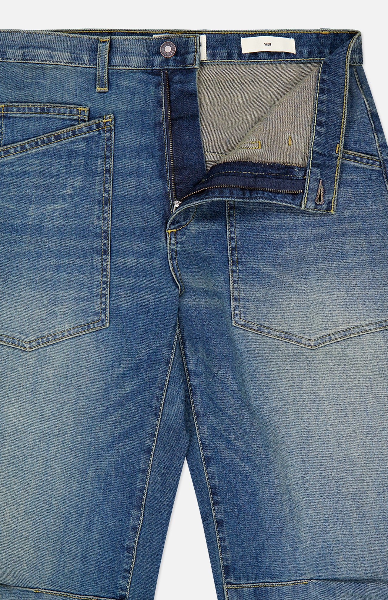Nili Lotan Shon Jean in Classic Wash: mid-rise, bow-leg blue denim jeans featuring a zip fly and large patch pockets on the front.