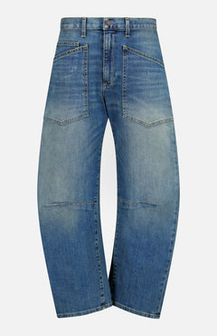 Nili Lotan Shon Jean in Classic Wash: mid-rise blue jeans with a curved, wide-leg bow leg silhouette and two large patch pockets on the front.
