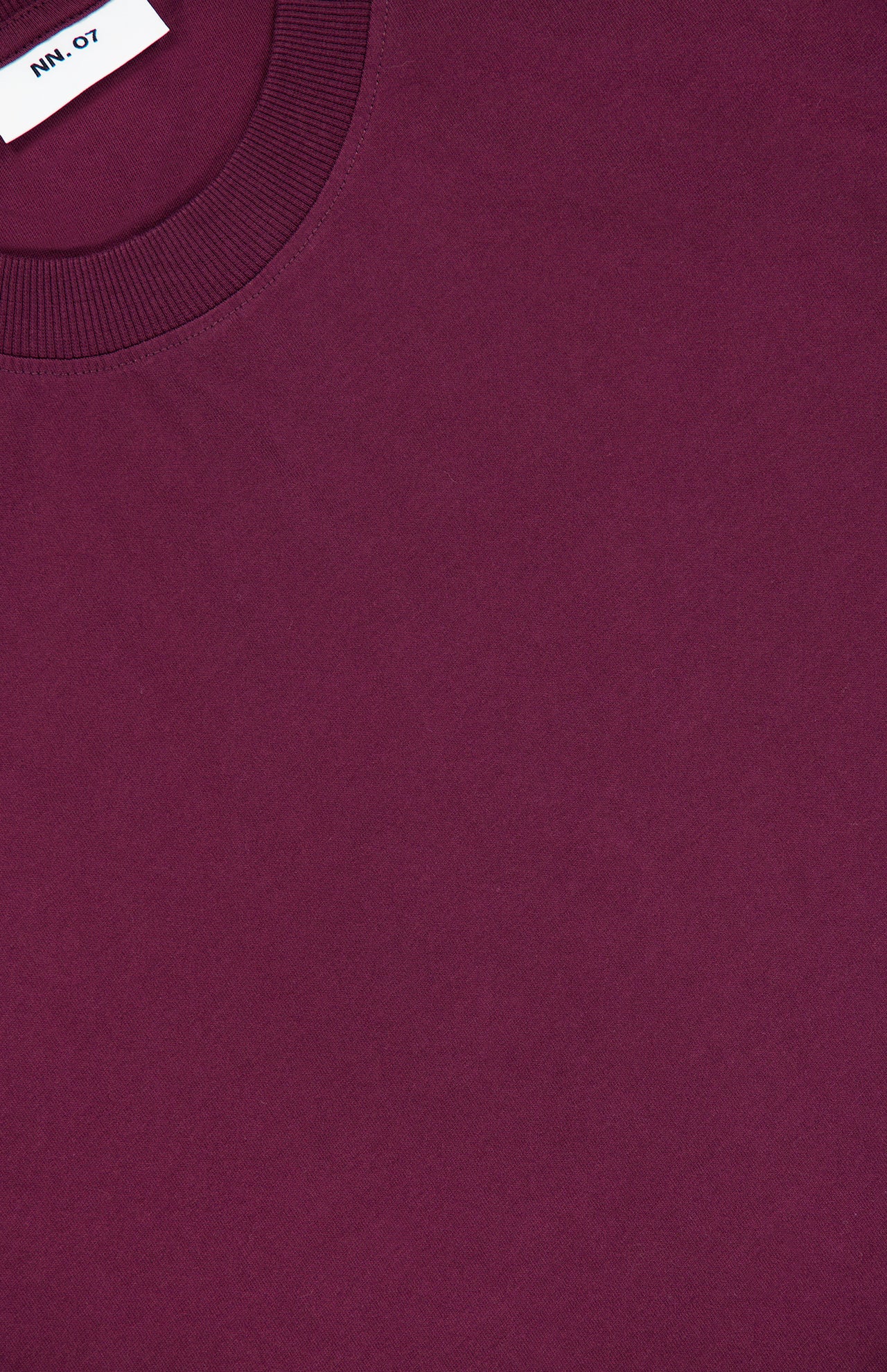 Close-up of the Adam Crewneck T-Shirt by NN07 in dark red, perfect for a modern-casual wardrobe, featuring a classic crew neck and a small white NN07 label partially visible near the collar.