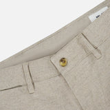 Close-up of the Aden Office Stretch Pant by NN07 in light grey, made from an organic cotton blend with a brown button, belt loops, and visible waistband label—perfect for a modern-casual look.
