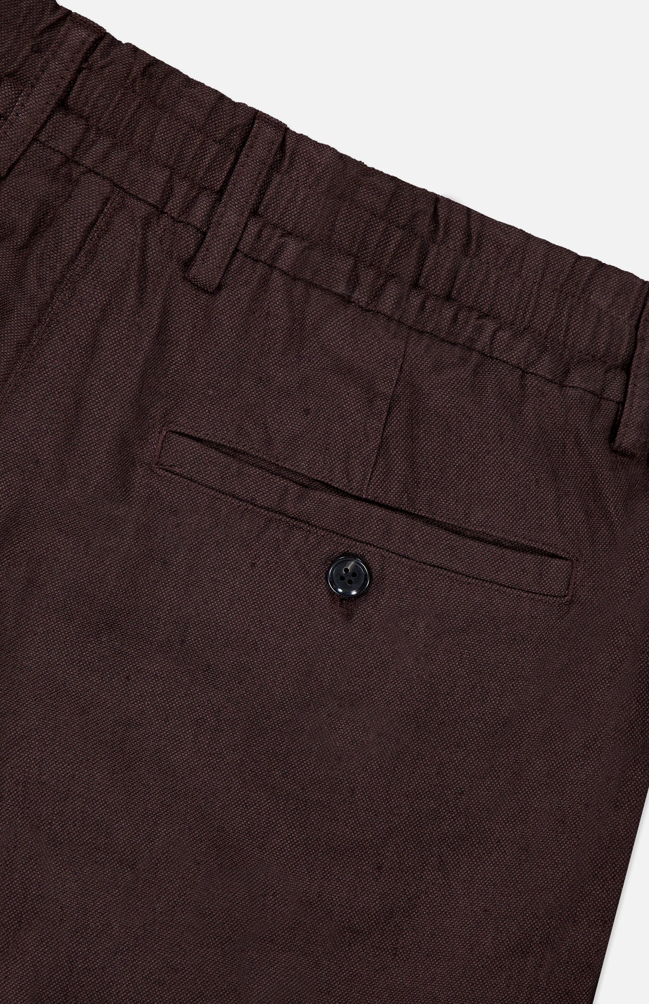 Close-up of NN07's Billie Drawstring Shorts in dark brown, featuring a waistband, belt loop, and a single back pocket with button closure. Made from textured cotton-linen viscose for comfort and style.