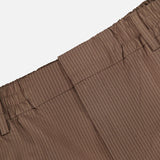 Close-up of the NN07 Billie Seersucker Trouser Pant’s waistband in brown, showcasing subtle vertical stripes, an elasticated waist with belt loops, visible seam detailing, and a clean, minimal finish.