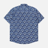 The Deon Short Sleeve Print Shirt by NN07 features a blue digital print with geometric and floral patterns on a dark blue background—an ideal modern-casual piece. Shown flat from the back with collar and button-up design.