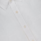 Close-up of the Deon Short Sleeve Linen Shirt by NN07, crafted from white linen with a pointed collar, white buttons, and a chest pocket—a timeless pick for modern-casual style.
