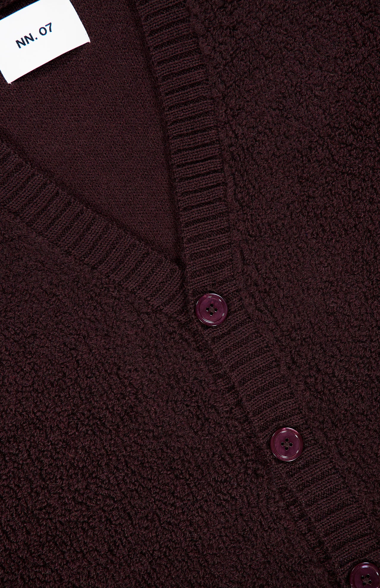 Close-up of the NN07 Fleece Cardigan Sweater in dark burgundy, featuring pure wool construction, ribbed edges, matching buttons, and a white collar label—an elegant upgrade for any modern-casual wardrobe.
