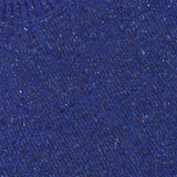 Close-up of the Jim Crew Neck Knitted Sweater by NN07, featuring a textured, speckled bright blue wool-blend jersey knit and a white NN07 label sewn into the ribbed neckline.