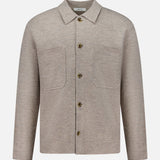 The Jonas Polo Button Down Long Sleeve Sweater by NN07 features a beige design with a collar, long sleeves, two large front chest pockets, and four brown buttons—ideal for a modern-casual wardrobe. This versatile wool shirt is showcased against a plain white background.