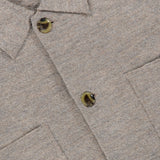 Close-up of the NN07 Jonas Polo Button Down Long Sleeve Sweater in beige-gray wool, ideal for a modern-casual wardrobe. Features include olive green buttons, two chest pockets, and a white NN07 brand label visible at the top left.