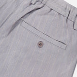 Close-up of the back pocket on the NN07 Kay Striped Linen Trouser Pant in light gray, showing a single button closure, belt loops at the waist, and a relaxed straight-leg fit.
