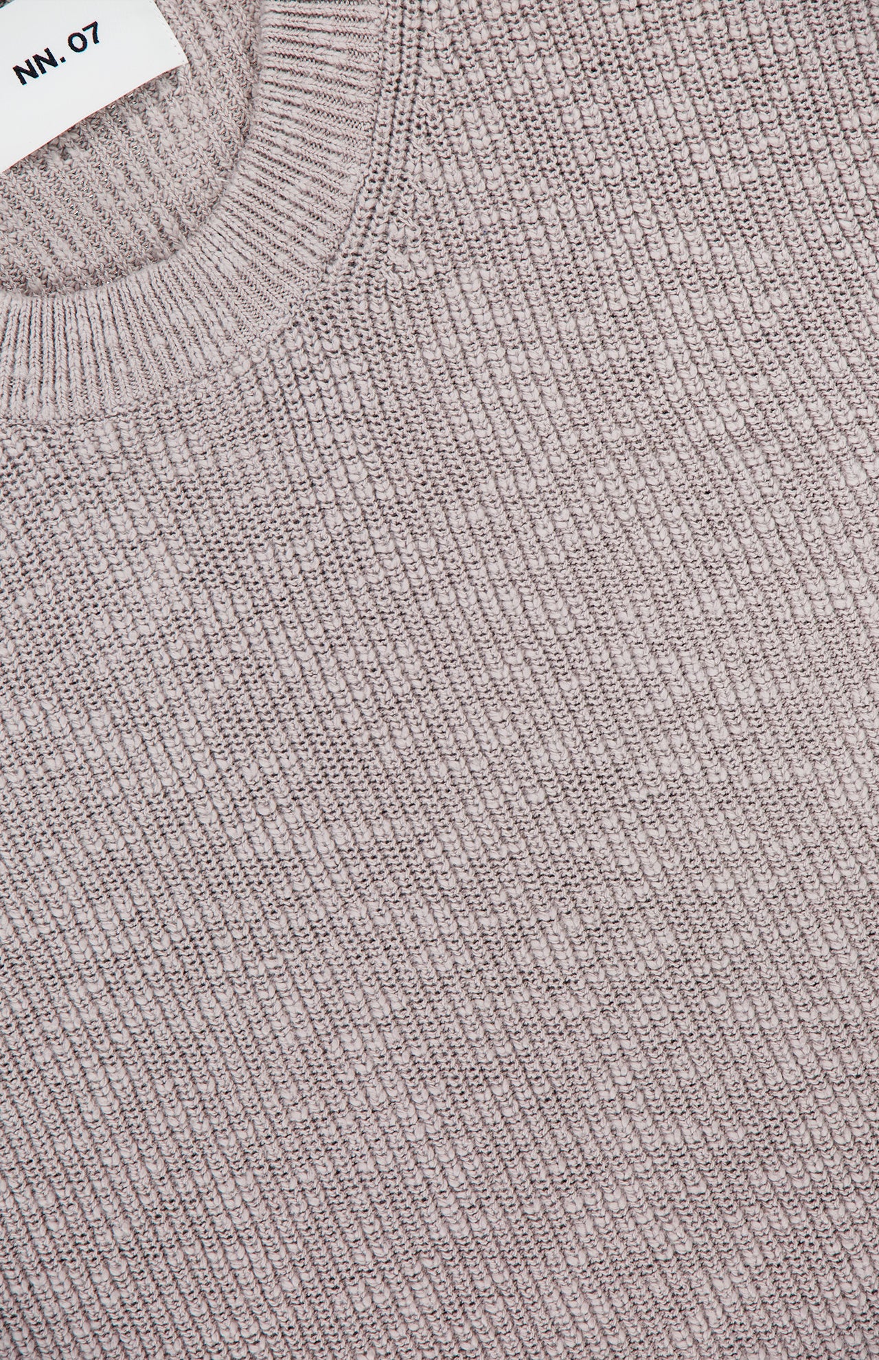 Close-up of the Russell Crewneck Sweater by NN07 in light gray, featuring bouclé-inspired textured fabric and a white NN07 label—an elevated, modern-casual essential.