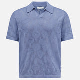 The Ryan Flower Design Short Sleeve Shirt by NN07 is a light blue organic cotton polo, featuring a subtle flower jacquard pattern, collar, and straight hem, shown on a plain white background.