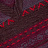 Close-up of the NN07 Tobias V-Neck Sweater, displayed in a rich berry colorway. The maroon and red patterned knit features horizontal geometric and zigzag designs, offering a modern-casual twist on the classic Fair Isle style. A white NN07 tag is visible near the collar.