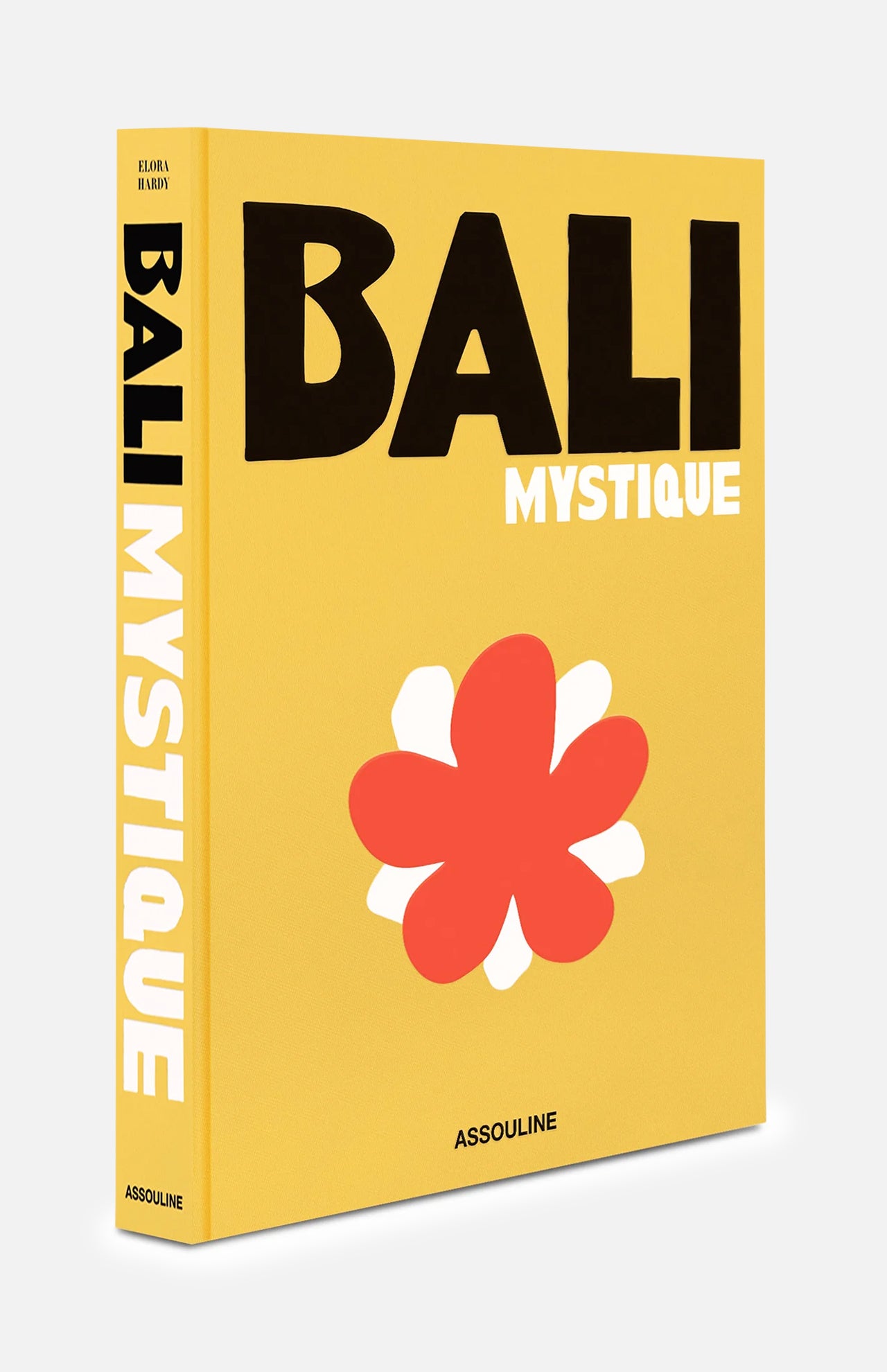 A vibrant yellow book titled Bali Mystique by ASSOULINE, featuring striking black and white text along with a bold red and white abstract flower on the cover, celebrates the allure of Bali travel and encapsulates the island’s dynamic spirit.
