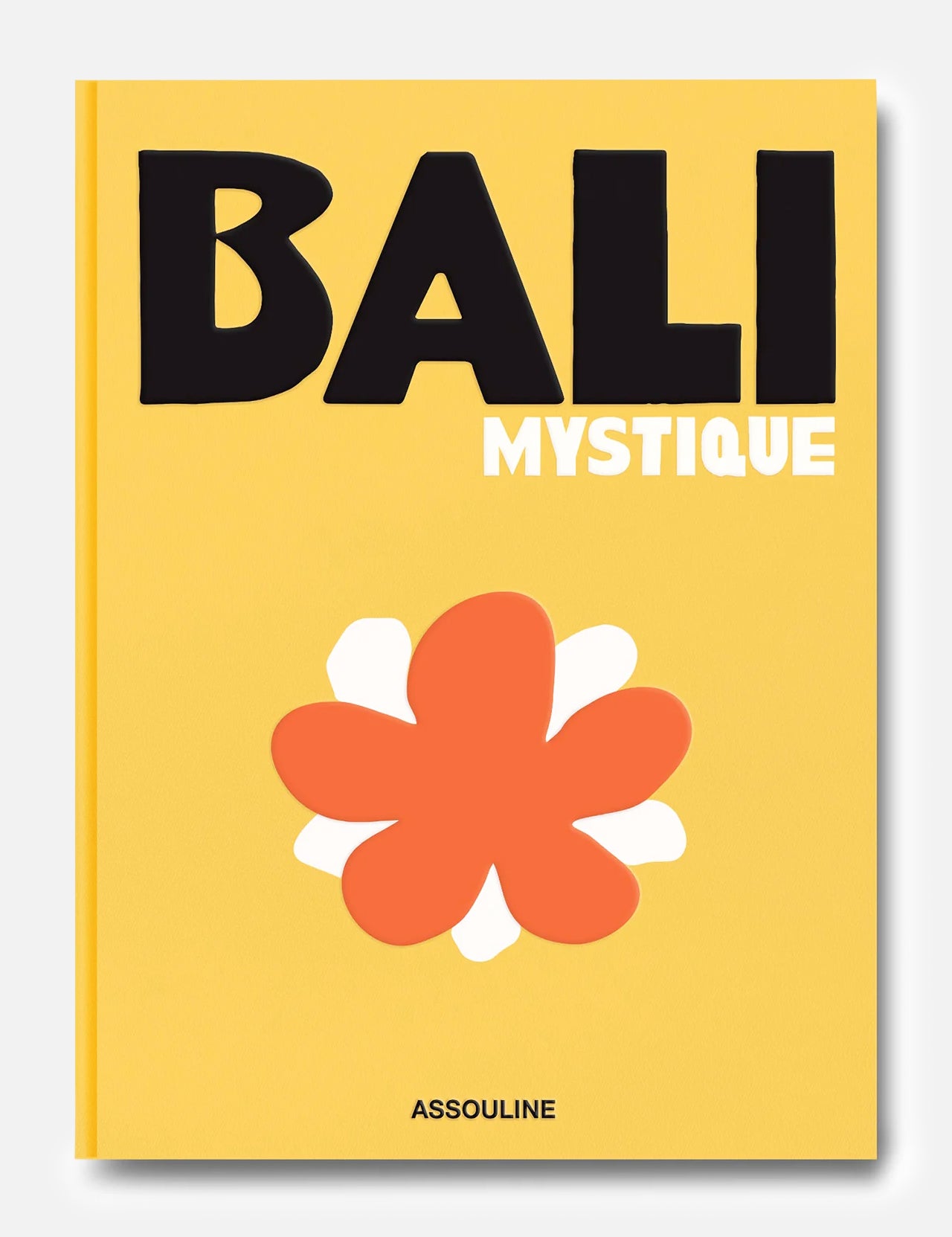 A yellow book cover titled Bali Mystique in bold black and white letters features a large, stylized orange and white flower below the title. Reflecting the spirit of Bali travel and its vibrant surfing community, this edition captures the island’s unique allure. The brand name ASSOULINE is printed at the bottom.