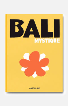 A yellow book cover titled Bali Mystique in bold black and white letters features a large, stylized orange and white flower below the title. Reflecting the spirit of Bali travel and its vibrant surfing community, this edition captures the island’s unique allure. The brand name ASSOULINE is printed at the bottom.