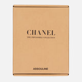 A chic brown cardboard box highlights sleek minimalism, with "Chanel: The Impossible Collection" in bold black and ASSOULINE centered below—a sophisticated collector’s piece for those who admire timeless fashion.