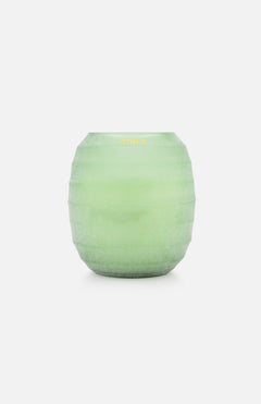 The ONNO Waves Green S is a frosted light green, round glass vase with horizontal ridges, reminiscent of luxury candles, showcased against a plain white background.