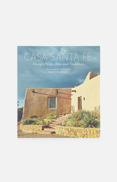 Book cover of Casa Santa Fe: Design, Style, Arts, and Tradition by RIZZOLI, showcasing an adobe-style house with stucco walls, desert landscaping, stone path, and a cloudy sky.
