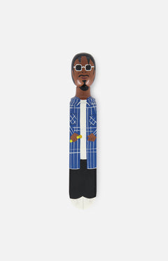 WEDGIE's 'Stoop Dog' Wood Door Stopper is a hand-painted figurine with brown skin, glasses, a beard, blue and white plaid shirt, white top, and black pants—perfect as a unique doorstop for any plain white background.