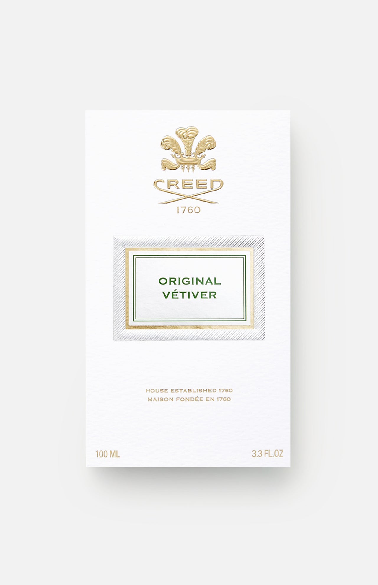 A white and gold box of CREED Original Vetiver displays the brand’s crest, 1760, and product details. This elegant box holds 100 ml (3.3 fl oz) of CREED’s signature vetiver Eau de Parfum.