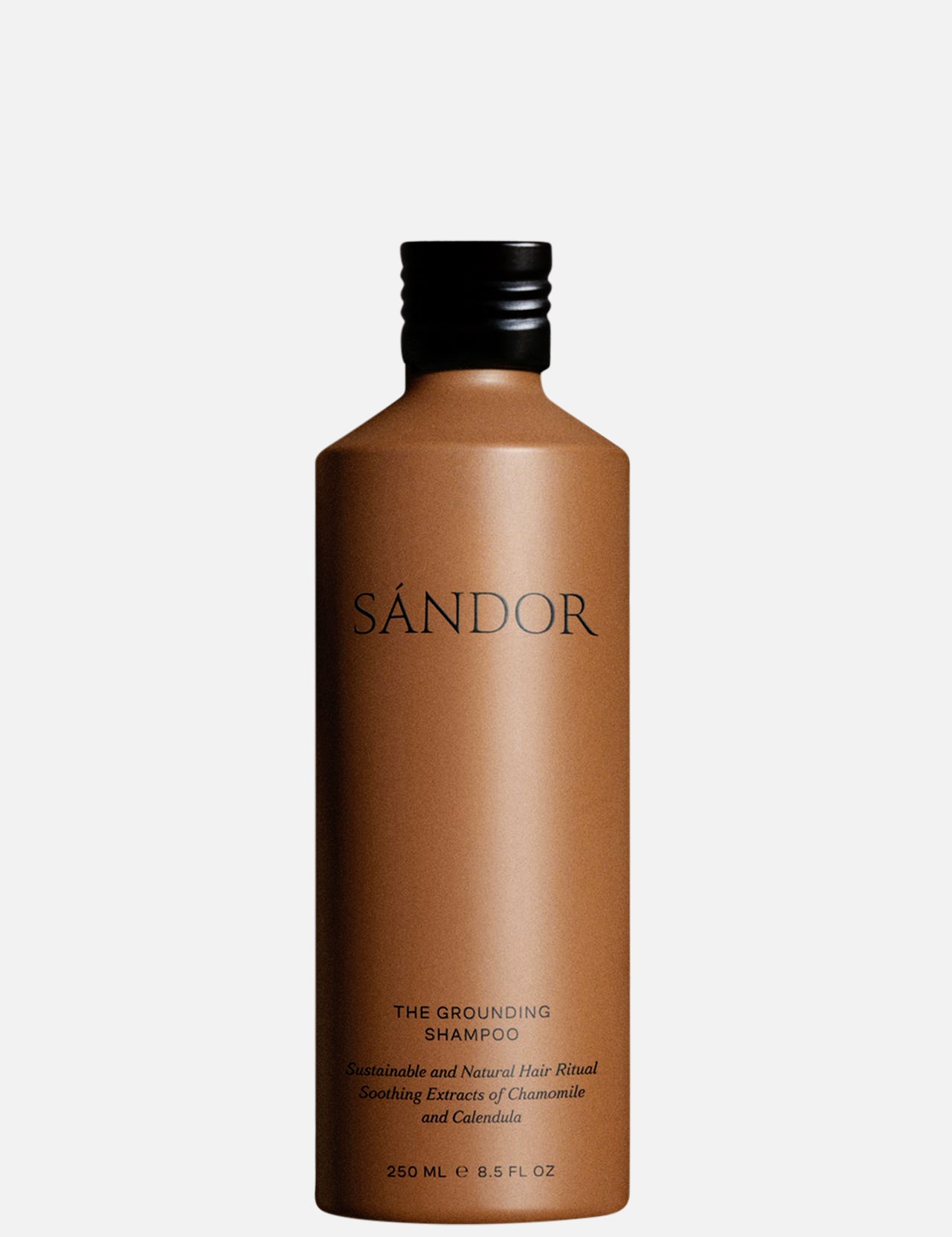 A 250 ml brown bottle of SÁNDOR The Grounding Shampoo with a black cap features minimalist black text. This plant-based shampoo nourishes the scalp and is formulated with organic aloe vera for gentle care.