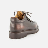 The OFFICINE CREATIVE Artik Flex Lace Low Boot is a brown airbrushed leather boot featuring a thick, rugged sole and tan interior, expertly handcrafted in Italy. Shown from the back left angle against a plain white background.