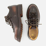 A pair of OFFICINE CREATIVE Artik Flex Lace Low Boots in dark brown Italian handcrafted leather, featuring rugged soles, metal eyelets, and black laces, displayed from the side and top on a white background.