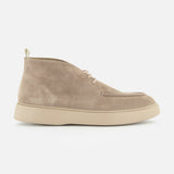 The Frame Suede Lace Chukka Boot by OFFICINE CREATIVE is a beige suede chukka boot, handmade in Italy, featuring a rounded toe, lace-up front, and a light-colored thick rubber sole, displayed in a side view on a plain white background.