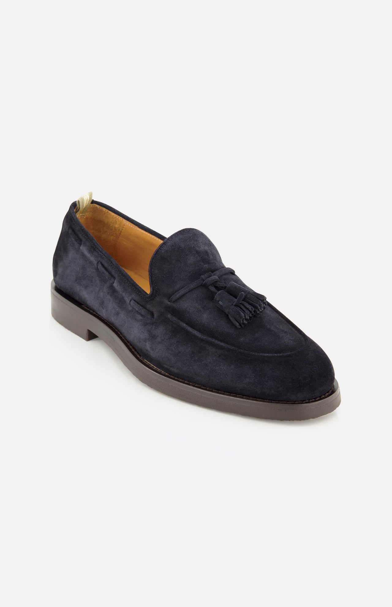 The Opera Flexi Tassel Loafer by OFFICINE CREATIVE is crafted from Italian navy blue suede and showcases refined tassels on the vamp, a rounded toe, light brown inner lining, and a flat brown sole, all elegantly presented against a white background.